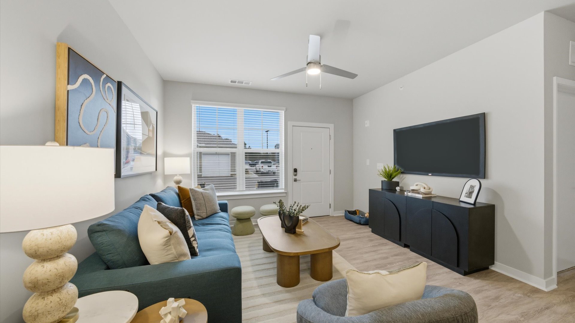 Sunlit apartment great room—wood‑look flooring, modern decor, and direct entry access at Authentix Town Creek.