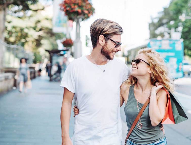 two-people-walking-down-the-street-with-shopping-bags