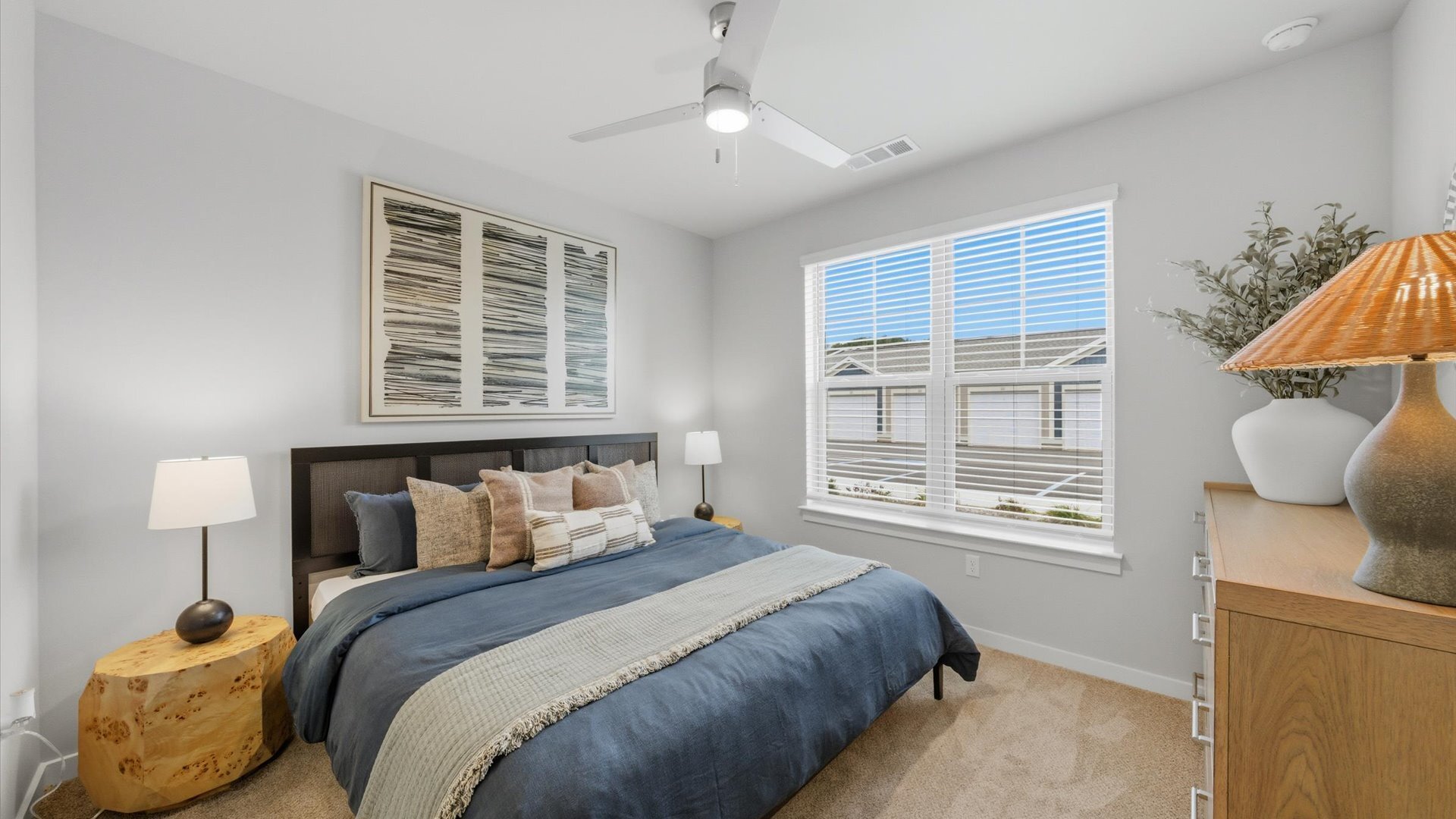 Cozy bedroom with queen bed, neutral bedding, and large artwork above headboard at Authentix Town Creek near Oak Ridge, TN.