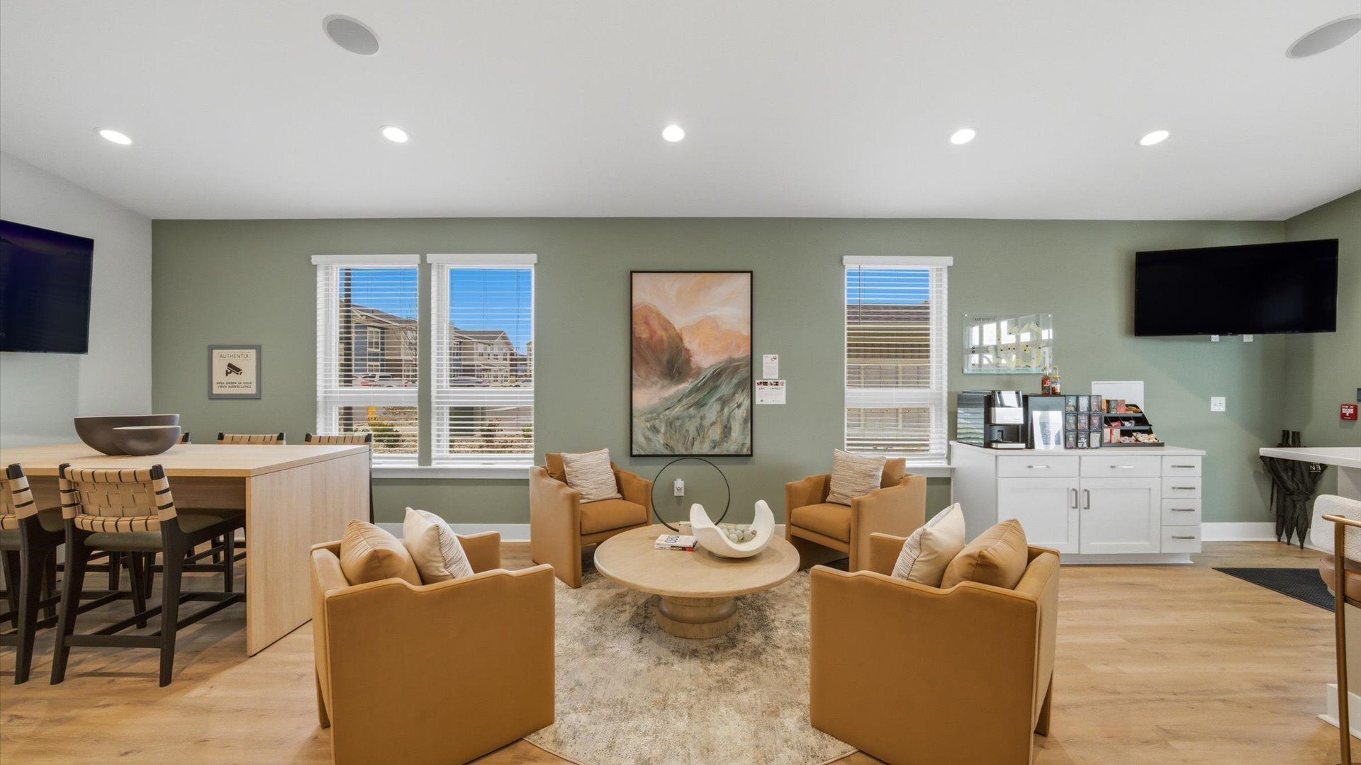 Clubhouse lounge with warm chairs, round coffee table, and bar seating at Authentix Town Creek in Lenoir City, TN.