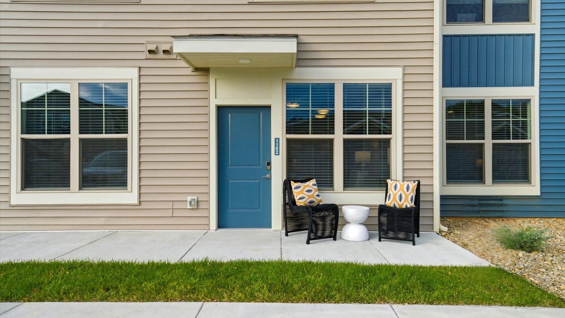 Blue front door with cozy patio seating and large windows at Authentix Town Creek, Lenoir City