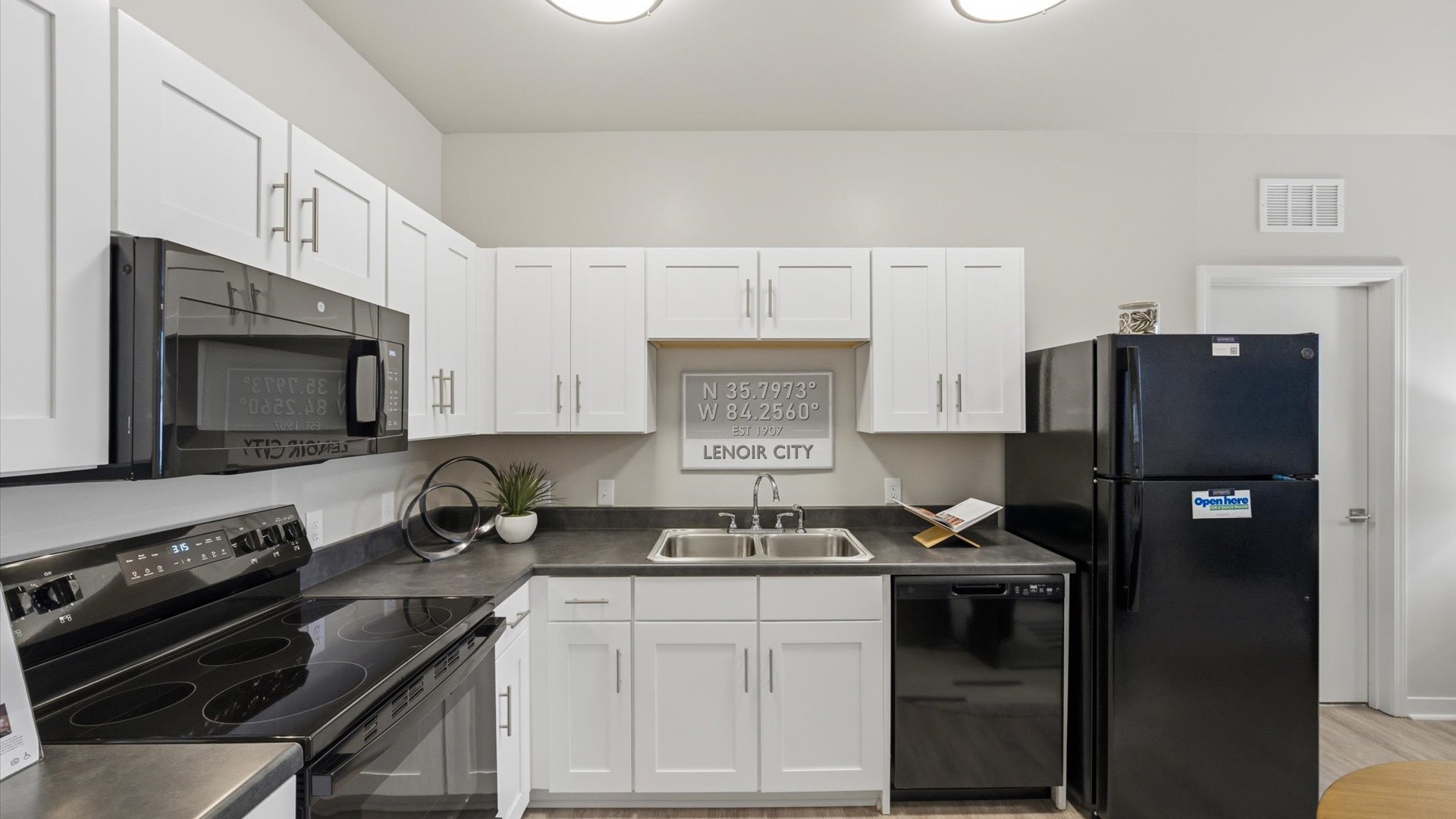 Contemporary kitchen with microwave, electric range, ample storage, and bright overhead lighting at Authentix Town Creek Near Knoxville, TN.