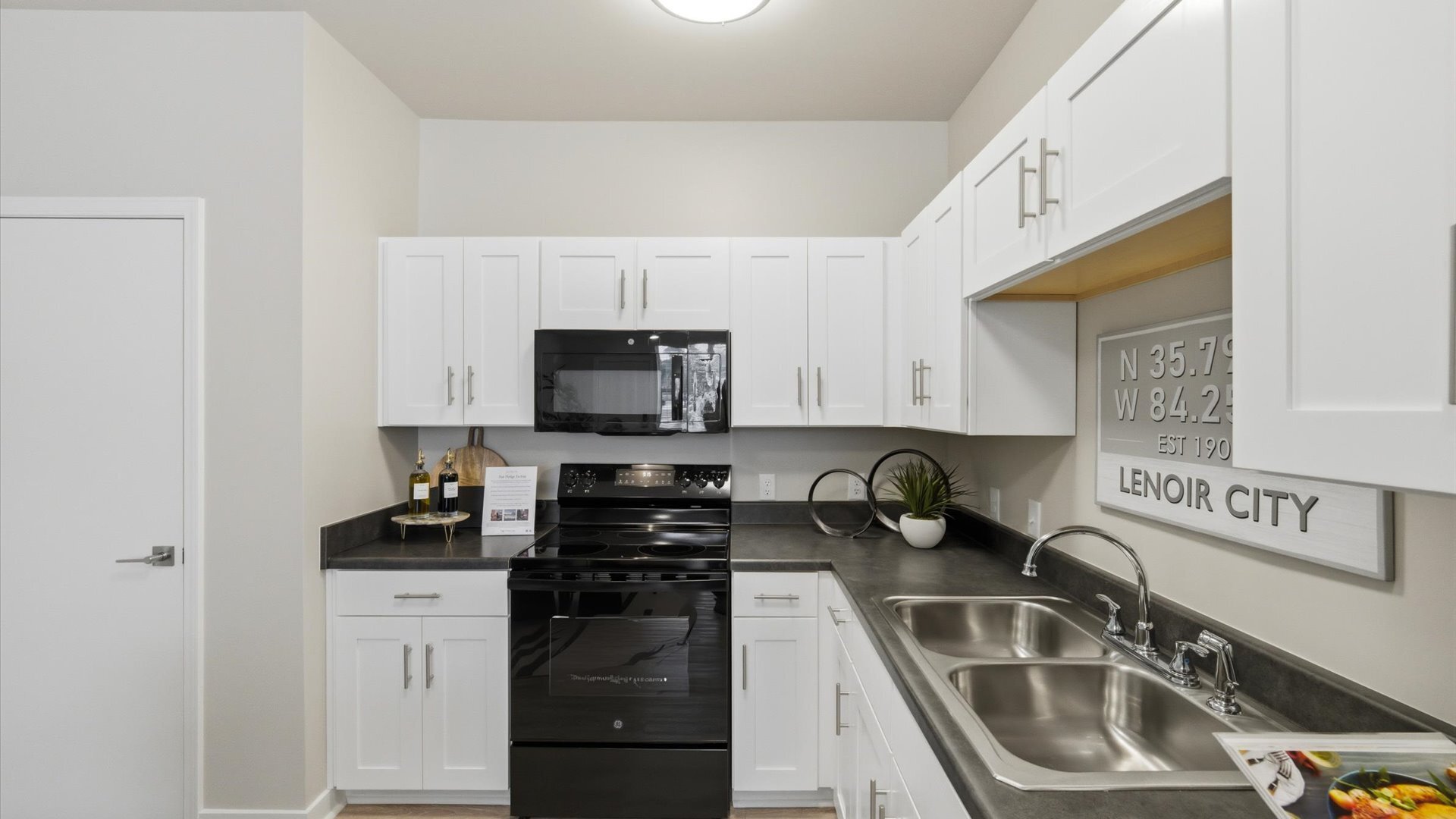 U‑shaped kitchen with black appliance package and white cabinets at Authentix Town Creek in Lenoir City, TN.