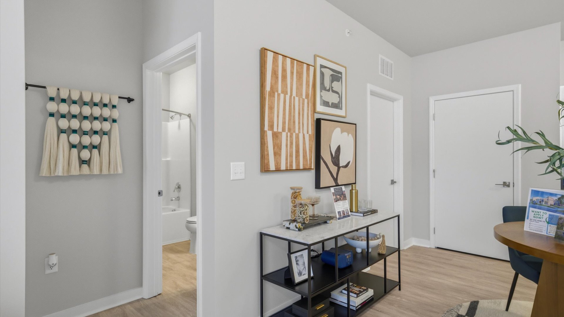 Modern wall art and console table near bathroom in model home at Authentix Town Creek in Lenoir City, TN.
